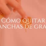 Close-up of a hand removing a grease stain from a white shirt using a cleaning spray, bright and clean background, realistic.